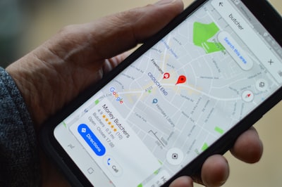 Hand holding a smartphone showing a local map search