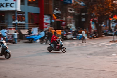 Scooter rider moving through a busy Indian city street