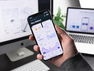 Hand holding a smartphone running a clean data dashboard app