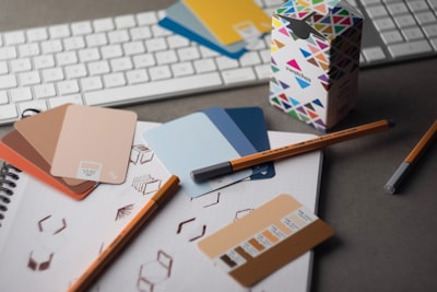 Designer's desk with colour swatch cards, pencils and a keyboard for brand work
