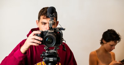 Videographer setting up a cinema camera to film a presenter on set
