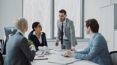 Small team discussing reports around a meeting table in a modern office