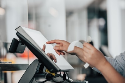 Person using a POS billing machine at a store counter