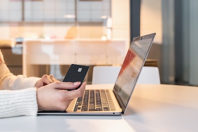 Woman shopping online with a laptop and phone