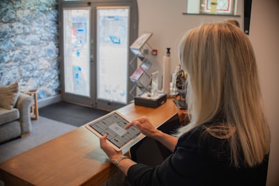 Receptionist using a tablet at a modern front desk