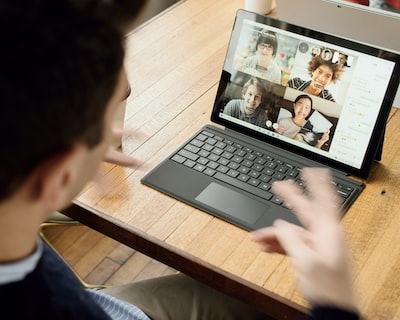 Engineer working remotely on a laptop video call from a home desk