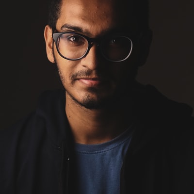 Portrait of a man in glasses and a dark crew-neck shirt